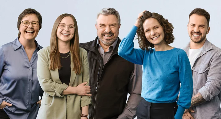 Fünf Personen, lachend nebeneinander. Drei Frauen und zwei Männer.